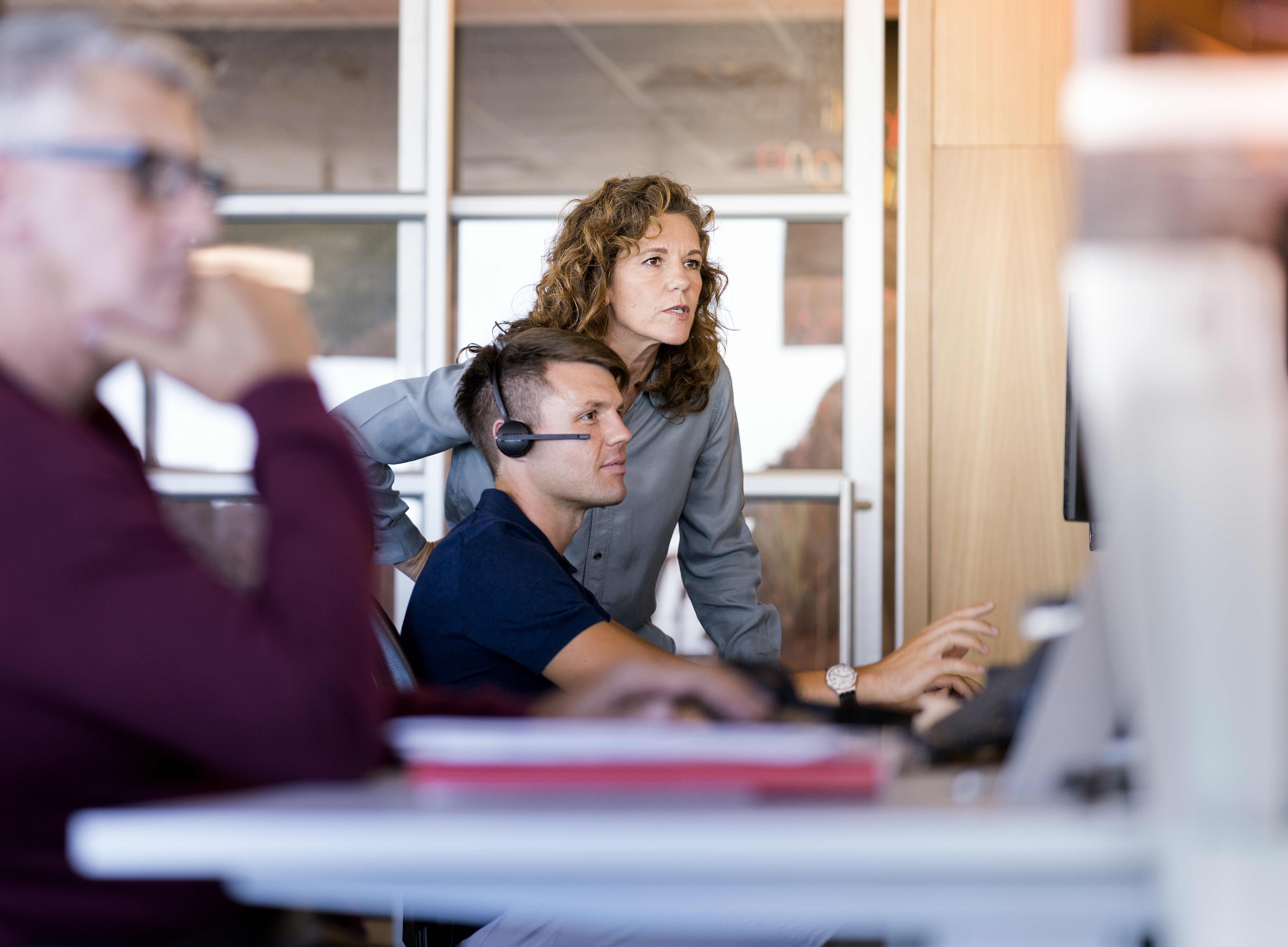 Professionals discussing over computer at desk